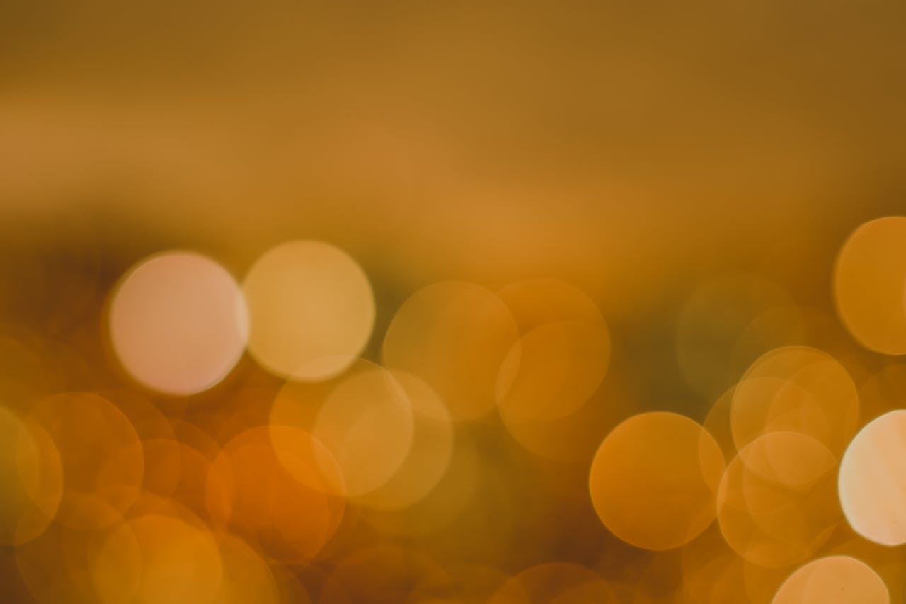 Abstract golden bokeh background with glowing circles, perfect for festive designs.